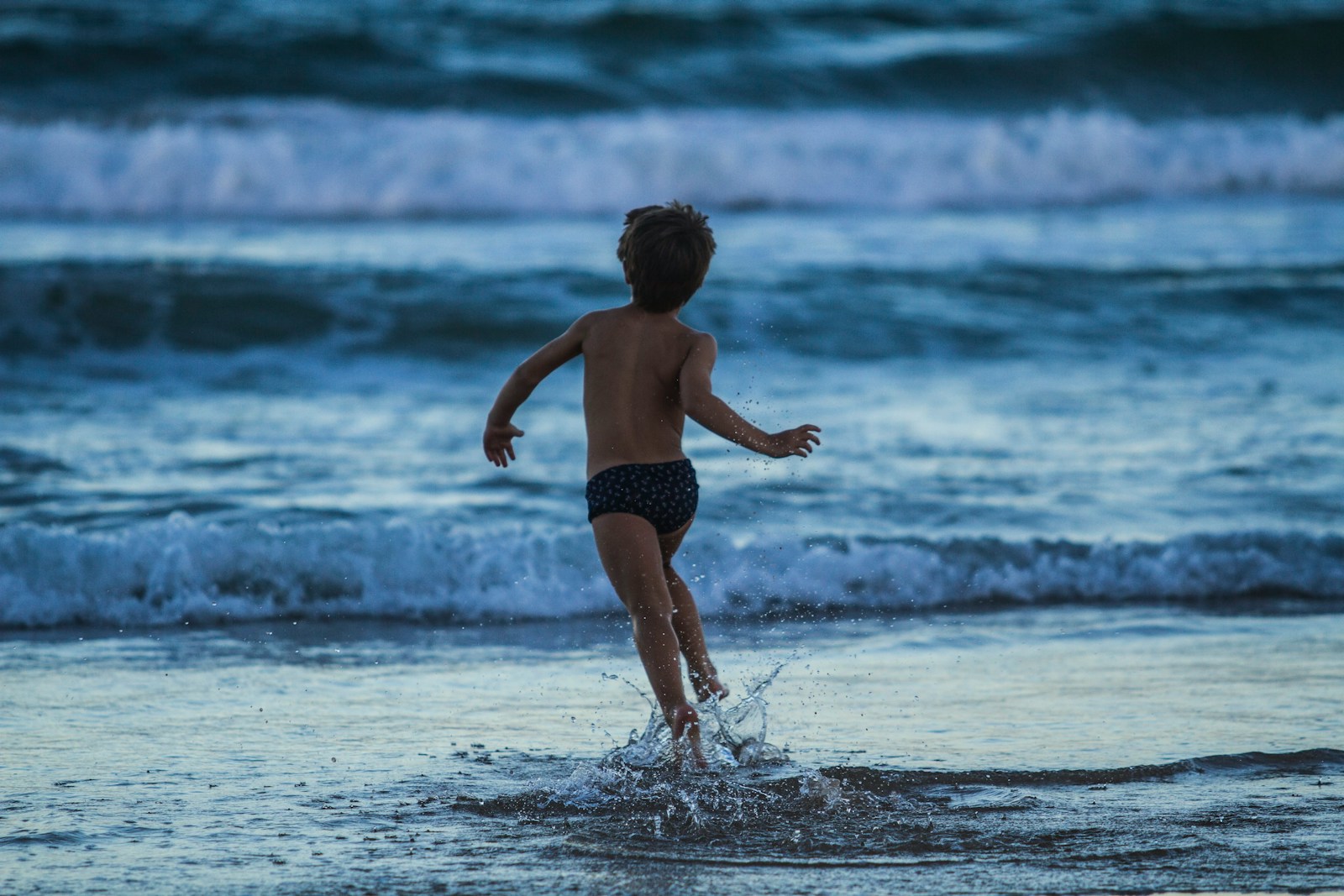 boy running towards seashore